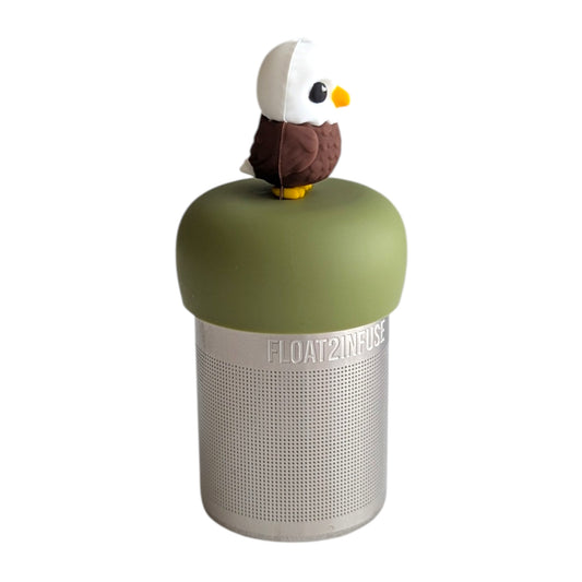 Side view of cute bald eagle tea infuser for loose leaf tea with a fine mesh stainless steel tea strainer
that reads FLOAT2INFUSE on a green base with a white background