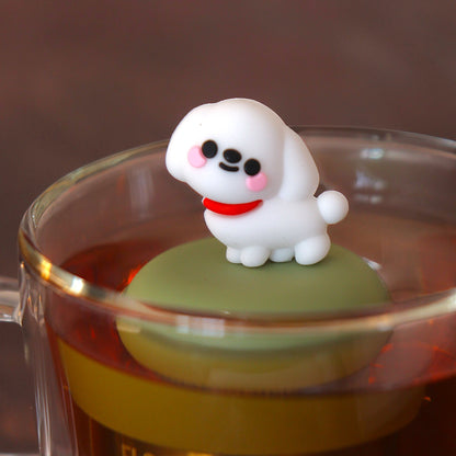 cute white maltese dog animal tea infuser for loose leaf tea  with a fine mesh stainless steel tea infuser that reads FLOAT2INFUSE on a green base floating in a glass tea mug