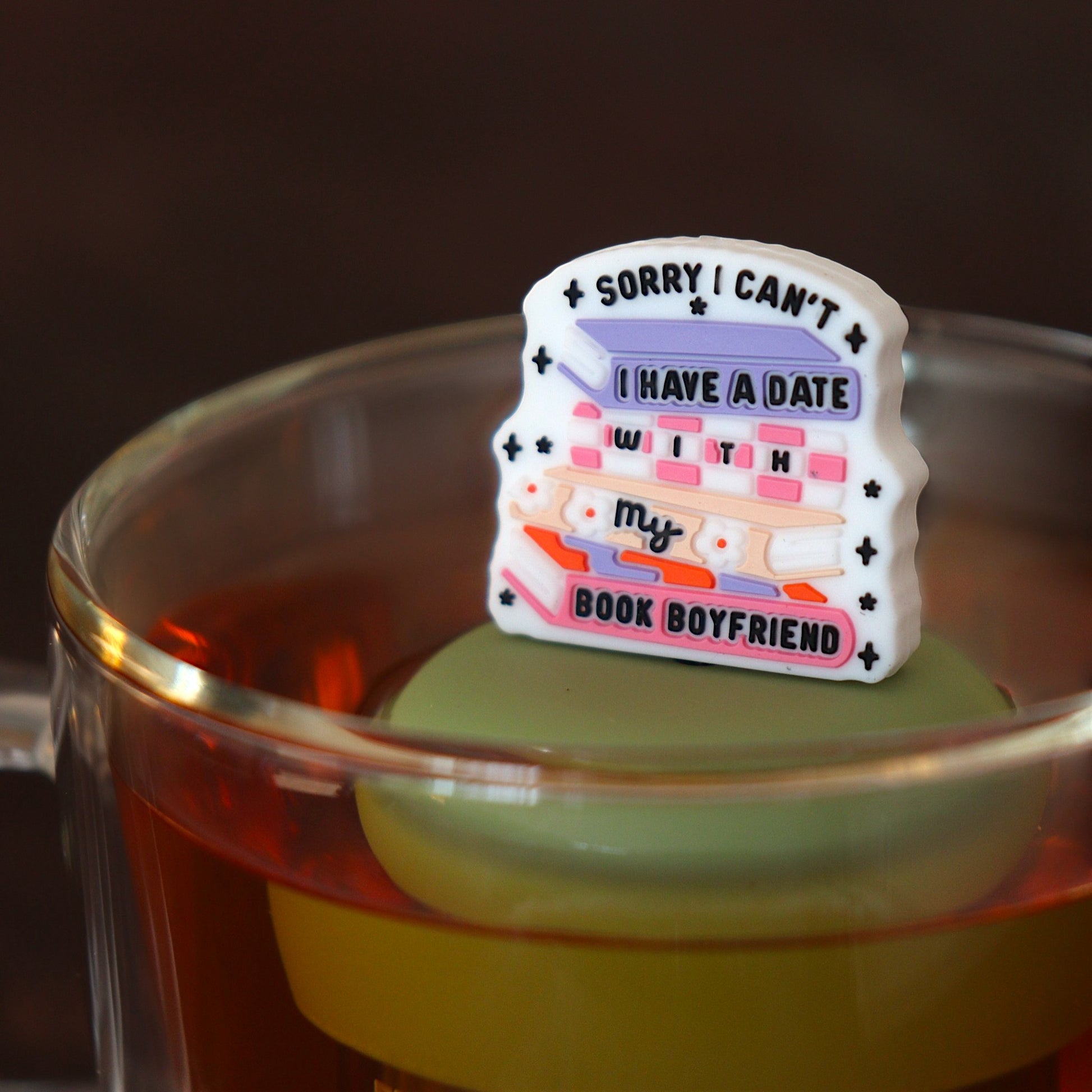 text on white background that reads "sorry i can't i have a date with my book boyfriend" on books tea infuser for loose leaf tea with a fine mesh stainless steel tea infuser that reads FLOAT2INFUSE on a green base floating in a glass tea mug
