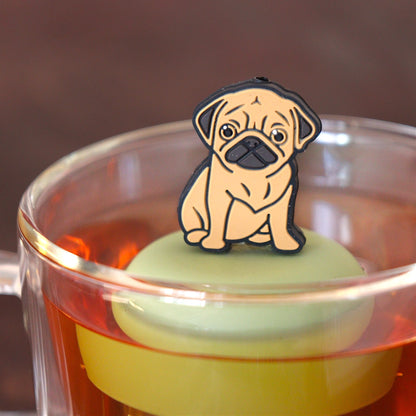 brown pug dog animal tea infuser for loose leaf tea on a green base with a fine mesh stainless steel tea infuser that reads FLOAT2INFUSE floating in a glass tea mug