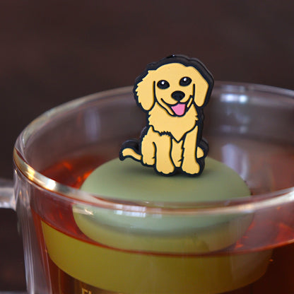 yellow smiling dog animal tea infuser for loose leaf tea on a green base with a fine mesh stainless steel tea infuser that reads FLOAT2INFUSE floating in a glass tea mug 
