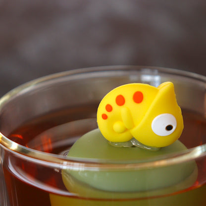 yellow lizard animal tea infuser for loose leaf tea on a green base with a fine mesh stainless steel tea infuser that reads FLOAT2INFUSE floating in a glass tea mug