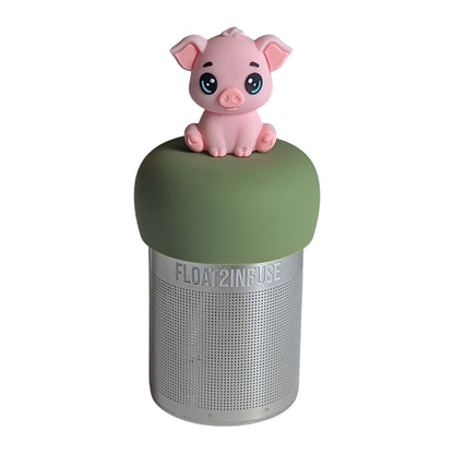 Adorable pink baby pig tea infuser for loose leaf tea with a fine mesh stainless steel tea strainer that reads FLOAT2INFUSE on a green base with a  white background
