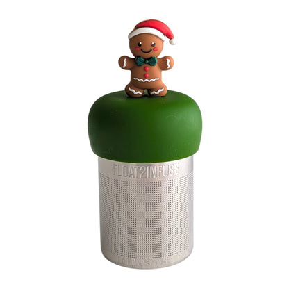 Smiling gingerbread man with a green bowtie, red santa hat and red buttons tea infuser for loose leaf tea with a fine mesh stainless steel tea strainer 
that reads FLOAT2INFUSE on a dark green base with a white background

