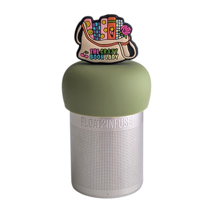Beige bag with several brightly colored books sticking out the top and  the text "the crazy book lady" written on the bottom tea infuser for loose leaf tea with a fine mesh stainless steel tea strainer 
that reads FLOAT2INFUSE on a green base with a white background
