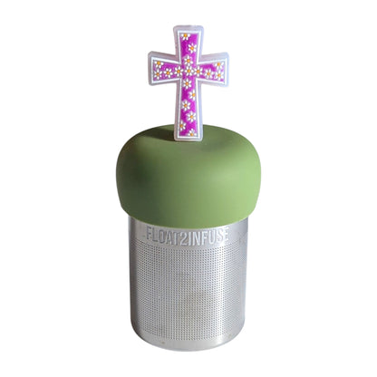 Purple cross with white polka dot daisies tea infuser for loose leaf tea with a fine mesh stainless steel tea strainer that reads FLOAT2INFUSE on a green base with a  white background
