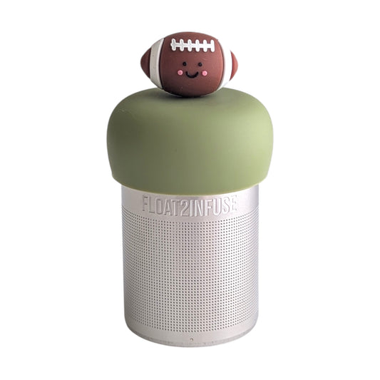 Cute smiling brown football tea infuser for loose leaf tea with a fine mesh stainless steel tea strainer 
that reads FLOAT2INFUSE on a green base with a white background

