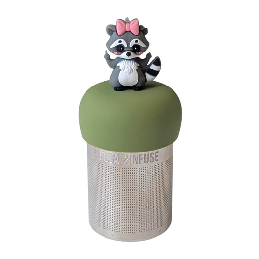 Cute raccoon with a pink bow flipping everybody off tea infuser for loose leaf tea with a fine mesh stainless steel tea strainer that reads FLOAT2INFUSE on a green base with a white background