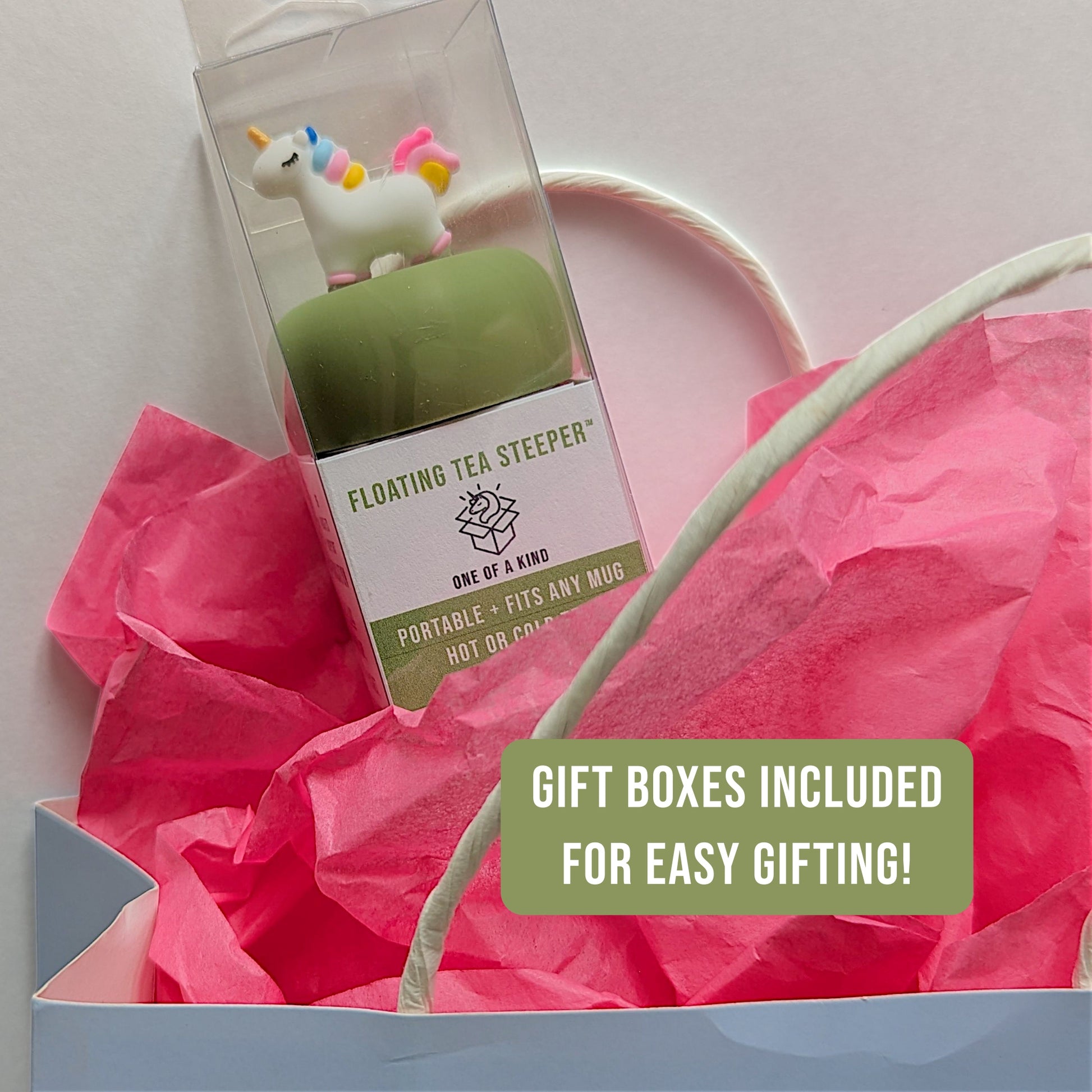 a unicorn Floating tea infuser in a plastic gift box coming out of a gift bag with pink tissue paper that says "gift boxes included for easy gifting!"