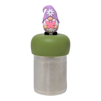 Purple gnome holding pink butterfly tea infuser  for loose leaf tea with a fine mesh stainless steel tea strainer that reads FLOAT2INFUSE on a green base with a white background