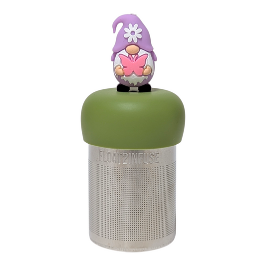 Purple gnome holding pink butterfly tea infuser  for loose leaf tea with a fine mesh stainless steel tea strainer that reads FLOAT2INFUSE on a green base with a white background