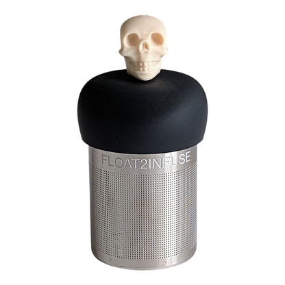 ivory skull tea infuser for loose leaf tea with a fine mesh stainless steel tea strainer that reads FLOAT2INFUSE on a black base with a white background