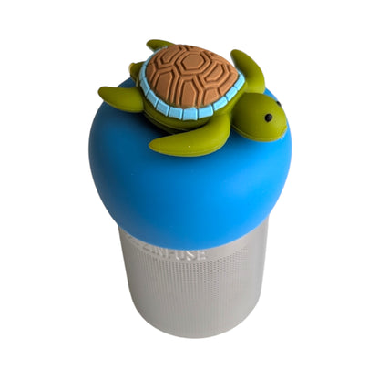 Cute green sea turtle with brown shell tea infuser for loose leaf tea with a fine mesh stainless steel tea strainer that reads FLOAT2INFUSE on a blue base with a white background
