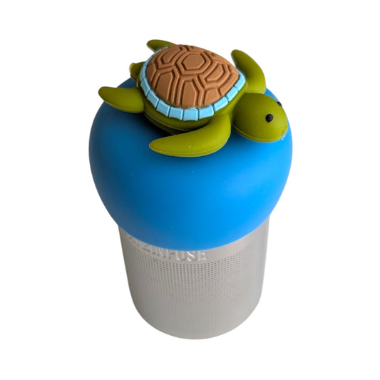 Cute green sea turtle with brown shell tea infuser for loose leaf tea with a fine mesh stainless steel tea strainer that reads FLOAT2INFUSE on a blue base with a white background
