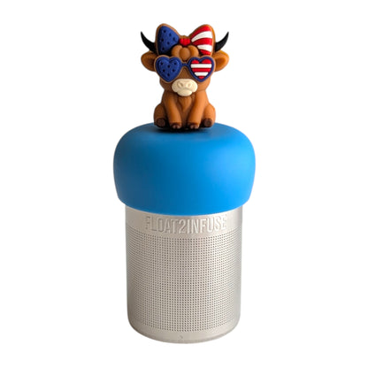 Cute cow wearing red white and blue heart shaped glasses and hairbow tea infuser for loose leaf tea with a fine mesh stainless steel tea strainer that reads FLOAT2INFUSE on a blue base with a white background
