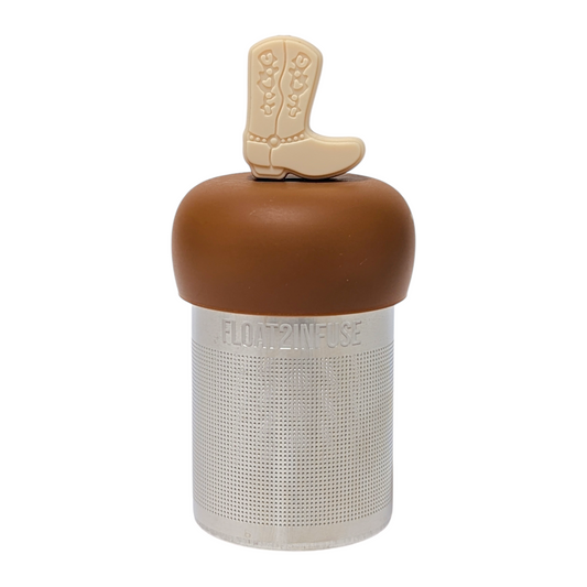 ivory cowboy boot tea infuser for loose leaf tea with a fine mesh stainless steel tea strainer that reads FLOAT2INFUSE on a brown base with a white background