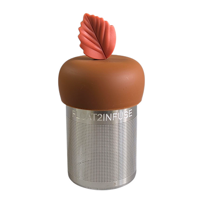 red fall leaf tea infuser for loose leaf tea with fine mesh stainless steel tea strainer that reads FLOAT2INFUSE on a brown base with a white background
