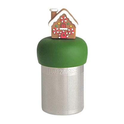 Brown gingerbread house with peppermint candy windows and snow on the roof tea infuser for loose leaf tea with a fine mesh stainless steel tea strainer that reads FLOAT2INFUSE on a dark green base with a white background