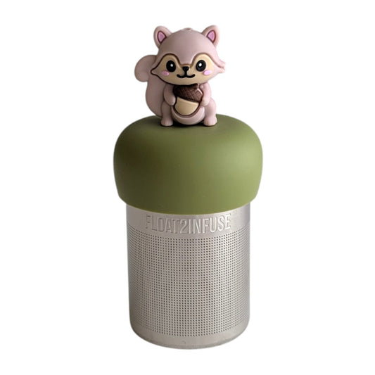 Cute 3D rose gold colored squirrel holding an acorn tea infuser for loose leaf tea with a fine mesh stainless steel tea strainer that reads FLOAT2INFUSE on a green base with a white background
