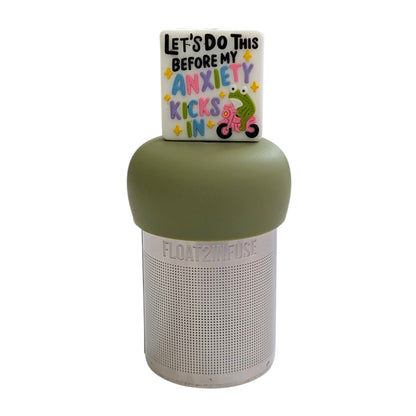 White square with text "let's do this before my anxiety kicks in" with a green frog riding a pink bike tea infuser for loose leaf tea with a fine mesh stainless steel tea strainer that reads FLOAT2INFUSE on a green base with a white background