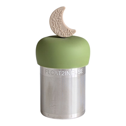beige crescent moon with raised floral pattern tea infuser  for loose leaf tea with fine mesh stainless steel tea strainer that reads FLOAT2INFUSE on a green base with white background