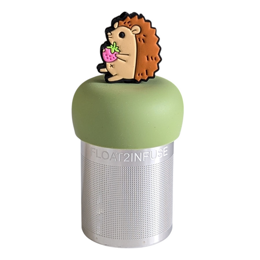 hedgehog animal holding strawberry tea infuser for loose leaf tea with a fine mesh stainless steel tea strainer that reads FLOAT2INFUSE on a green base with a white background