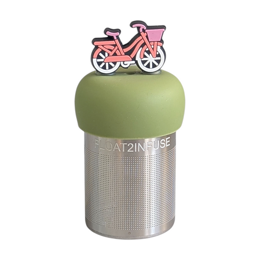 pink and white bicycle with a pink basket and white wheels tea infuser  for loose leaf tea with fine mesh stainless steel tea strainer that reads FLOAT2INFUSE on a green base with white background
