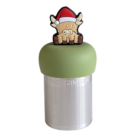 blonde highland cow animal wearing a santa hat tea infuser for loose leaf tea with a fine mesh stainless steel tea strainer that reads FLOAT2INFUSE on a green base with a white background