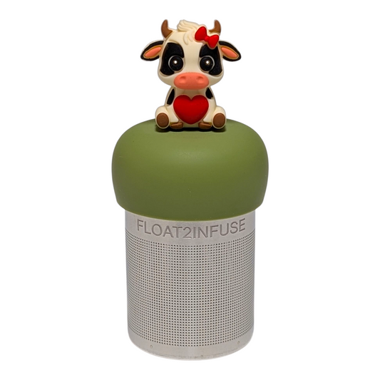 black and white cow with a red bow and a red heart tea infuser for loose leaf tea with a fine mesh stainless steel tea strainer  that reads FLOAT2INFUSE on a green base with a white background
