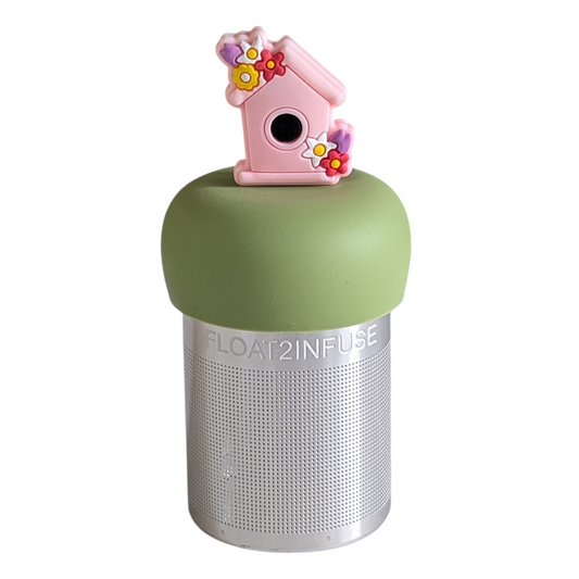 pink birdhouse with flower accents tea infuser for loose leaf tea with a fine mesh stainless steel tea strainer that reads FLOAT2INFUSE on a green base with a white background
