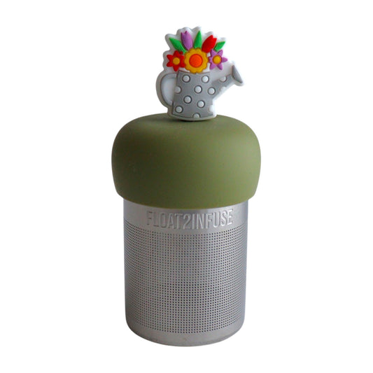 grey watering can with white polka dots and flowers growing out the top tea infuser for loose leaf tea with a fine mesh stainless steel tea strainer that reads FLOAT2INFUSE on a green base with a white background