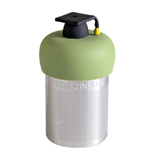 black graduation cap tea infuser for loose leaf tea with a fine mesh stainless steel tea strainer that reads FLOAT2INFUSE on a green base with a white background
