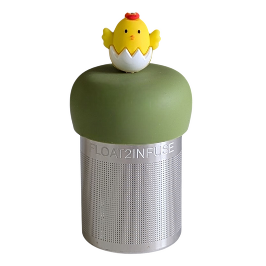 yellow chick animal hatching from white egg tea infuser for loose leaf tea with a fine mesh stainless steel tea strainer that reads FLOAT2INFUSE on a green base with a white background