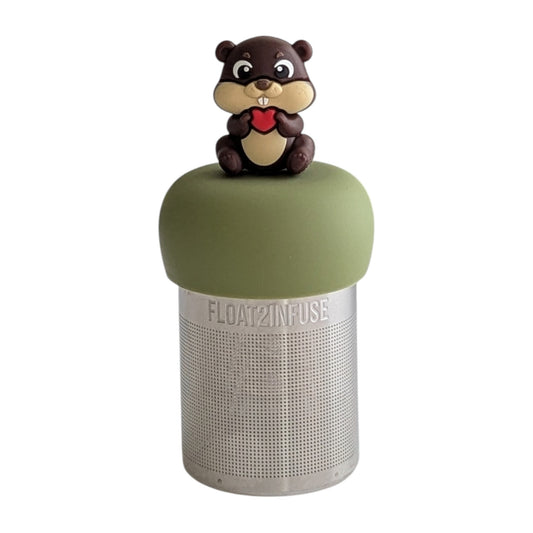beaver animal holding a red heart tea infuser for loose leaf tea on a green base with a fine mesh stainless steel tea strainer that reads FLOAT2INFUSE with a white background