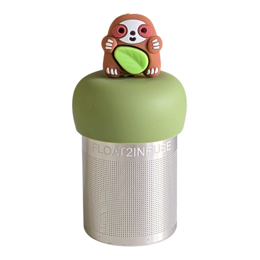 brown sloth animal holding a green leaf tea infuser for loose leaf tea with a fine mesh stainless steel tea strainer that reads FLOAT2INFUSE on a green base with a white background