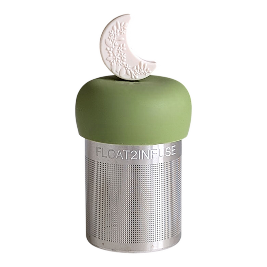 ivory crescent moon with raised floral pattern tea infuser  for loose leaf tea with fine mesh stainless steel tea strainer that reads FLOAT2INFUSE on a green base with white background