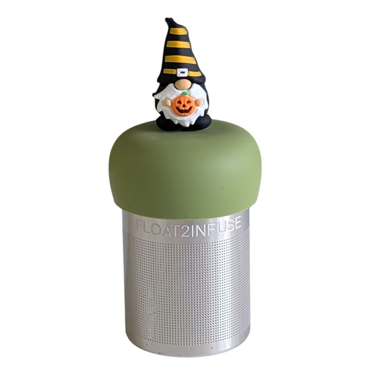 gnome with long white beard wearing black with yellow stripes and holding a jack-o-lantern pumpkin tea infuser for loose leaf tea with a fine mesh stainless steel tea strainer that reads FLOAT2INFUSE on a green base with a white background
