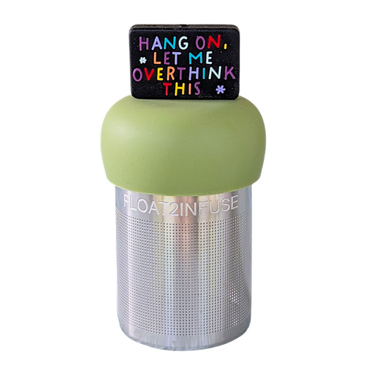 black rectangle with text that reads "hang on, let me overthink this" in rainbow letters tea infuser  for loose leaf tea with fine mesh stainless steel tea strainer that reads FLOAT2INFUSE on a green base with a white background