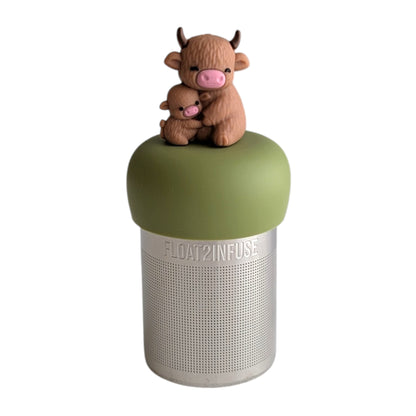 Momma highland cow hugging her baby tea infuser for loose leaf tea with a fine mesh stainless steel tea strainer that reads FLOAT2INFUSE on a green base with a white background
 