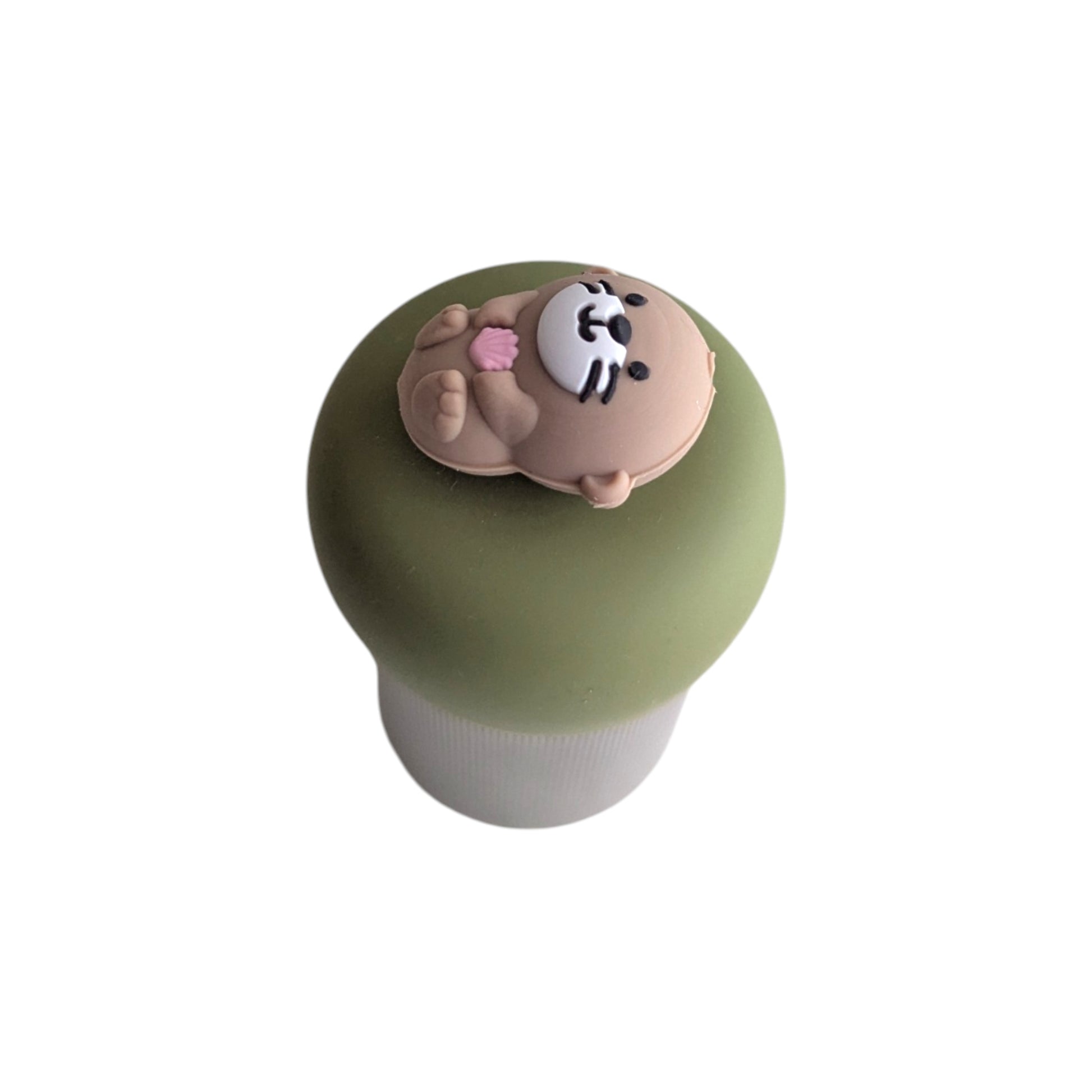 cute little otter floating on it's back holding a pink seashell tea infuser for loose leaf tea with a fine mesh stainless steel tea strainer 
that reads FLOAT2INFUSE on a green base with a white background