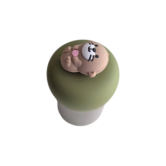 cute little otter floating on it's back holding a pink seashell tea infuser for loose leaf tea with a fine mesh stainless steel tea strainer 
that reads FLOAT2INFUSE on a green base with a white background