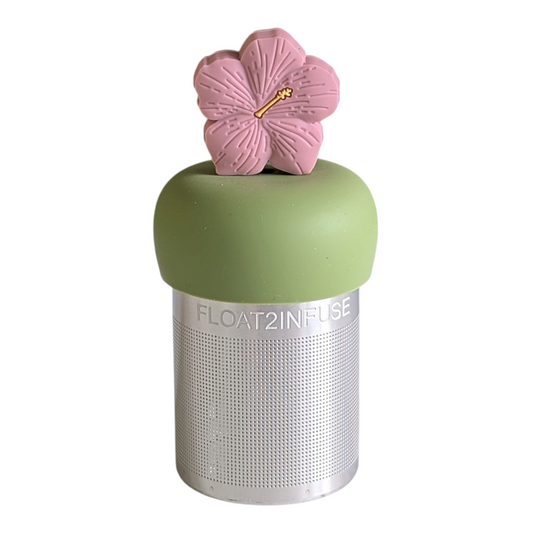 light pink hibiscus flower tea infuser for loose leaf tea with a fine mesh stainless steel tea strainer that reads FLOAT2INFUSE on a green base with a white background