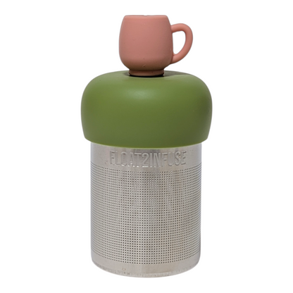 Pink mug tea infuser  for loose leaf tea with a fine mesh stainless steel tea strainer that reads FLOAT2INFUSE on a green base with a white background