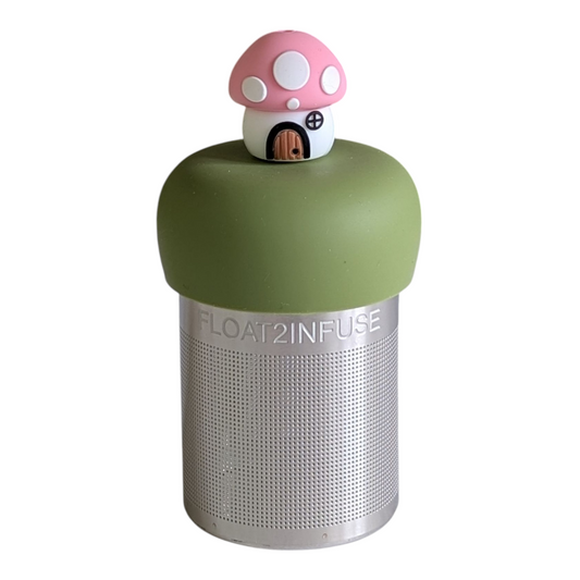 pink mushroom house tea infuser for loose leaf tea with a fine mesh stainless steel tea strainer that reads FLOAT2INFUSE on a green base with a white background