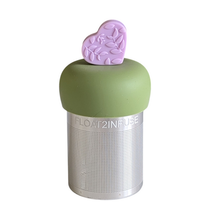 light purple heart with a floral pattern tea infuser for loose leaf tea with a fine mesh stainless steel tea strainer 
that reads FLOAT2INFUSE on a green base with a white background