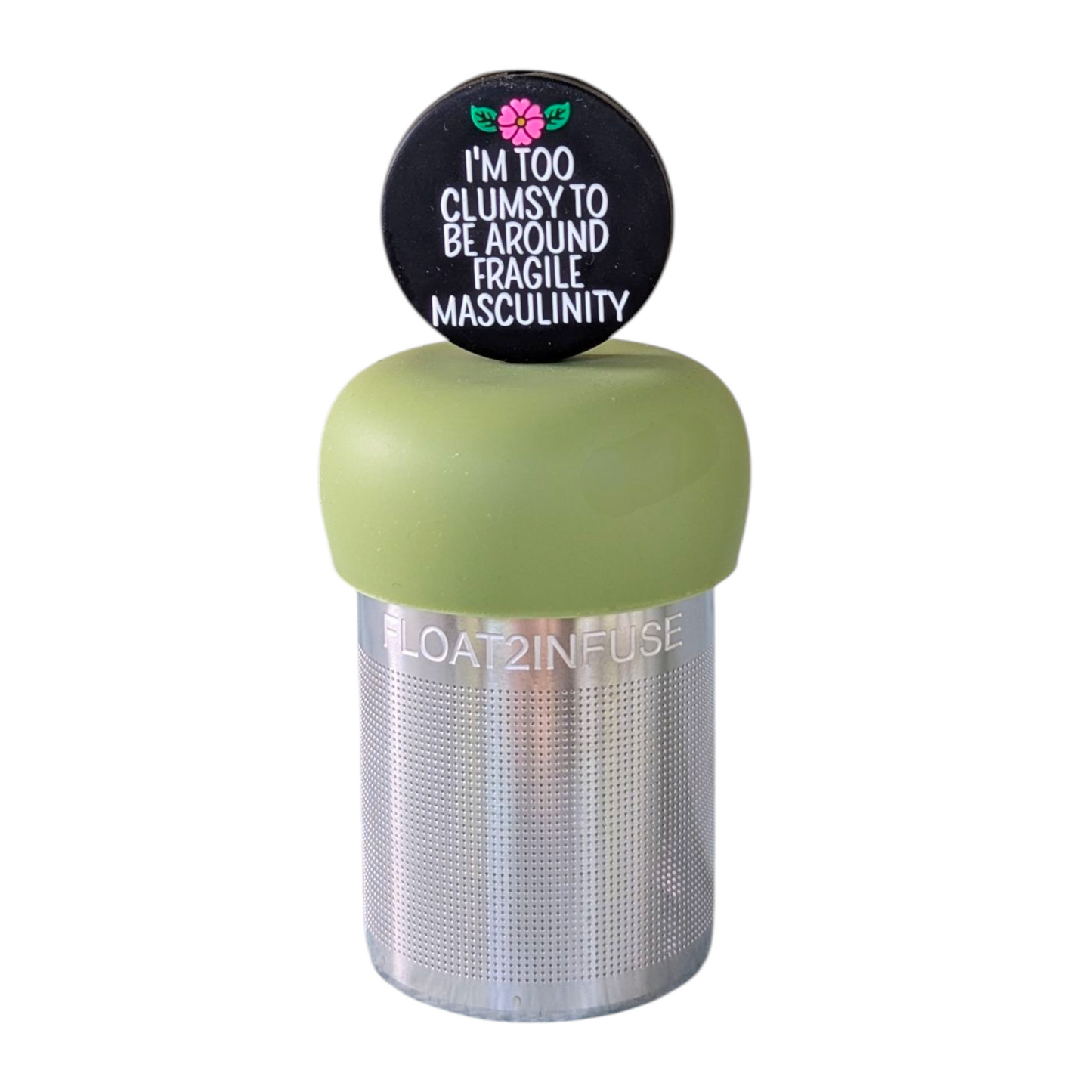 black circle with white text that reads "I'm too clumsy to be around fragile masculinity" with a pink  flower tea infuser  for loose leaf tea with fine mesh stainless steel tea strainer that reads FLOAT2INFUSE on a green base with a white background