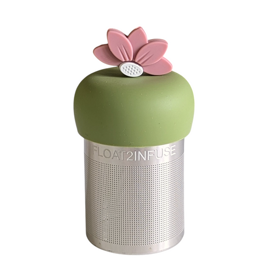 warm pink lotus flower tea infuser for loose leaf tea with a fine mesh stainless steel tea strainer that reads FLOAT2INFUSE on a green base with a white background