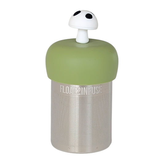 White mushroom with black spots tea infuser for loose leaf tea with a fine mesh stainless steel tea strainer that reads FLOAT2INFUSE on a green base with a white background