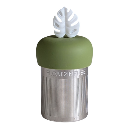 white monstera leaf tea infuser for loose leaf tea with a fine mesh stainless steel tea strainer that reads FLOAT2INFUSE on a green base with a white background