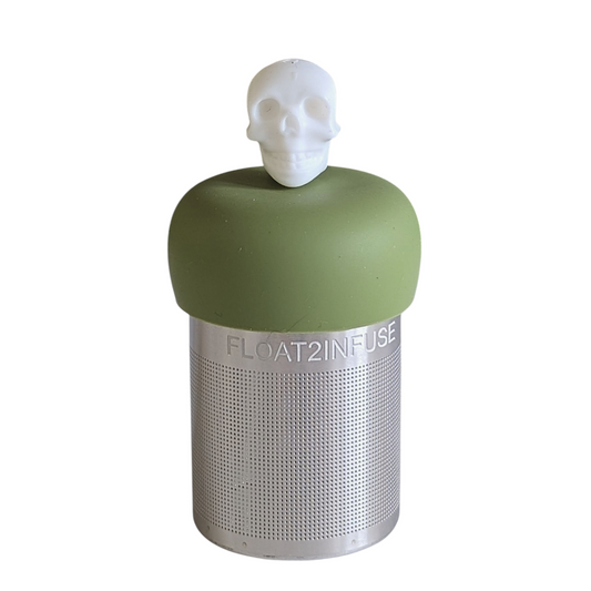 white skull tea infuser for loose leaf tea with a fine mesh stainless steel tea strainer that reads FLOAT2INFUSE on a green base with a white background